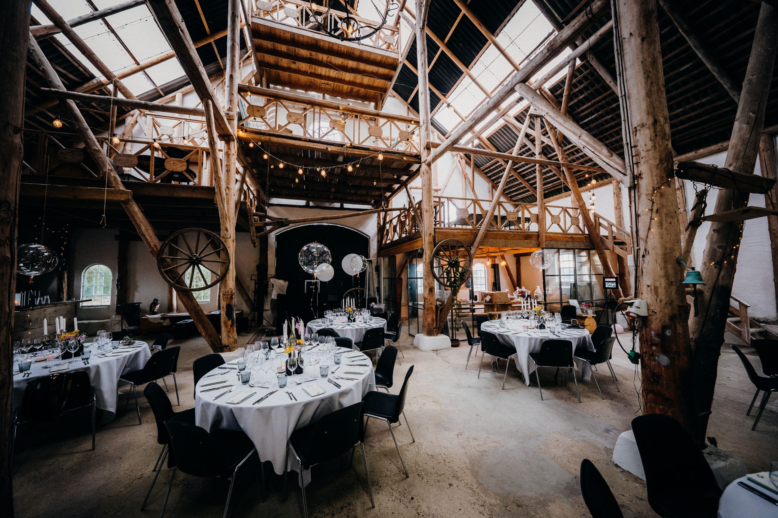 Salle de réception aménagée avec tables rondes pour un repas de mariage